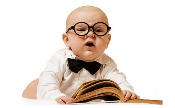 Bébé en tenue élégante feuilletant un livre ouvert lors d'un atelier bébé-lecteur.