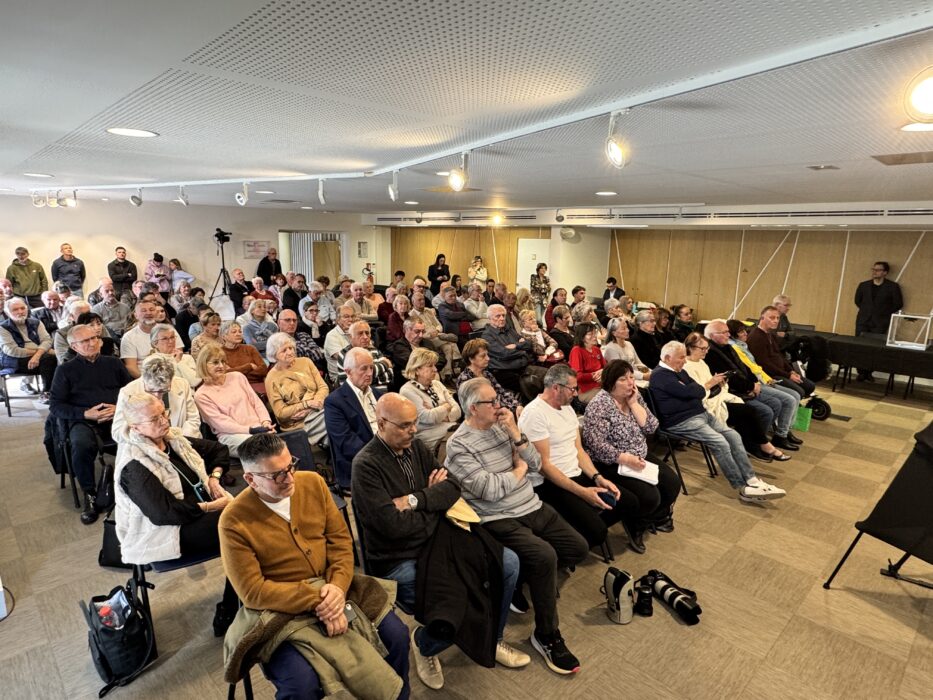 Public nombreux assis dans une salle municipale lors de la cérémonie d’investiture du conseil municipal.