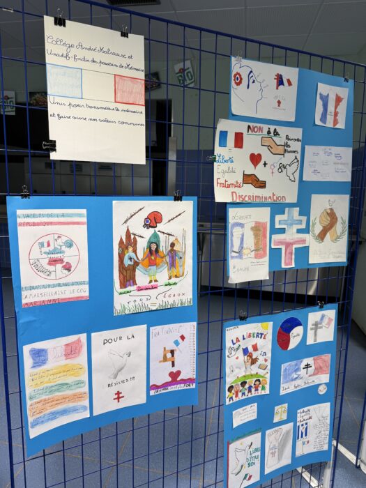 Exposition d’affiches réalisées par les élèves du collège André-Malraux de La Farlède pour la cérémonie de transmission du drapeau Unadif. Les affiches, accrochées sur des grilles bleues, illustrent les valeurs de liberté, égalité, fraternité, résistance et paix. On y voit des dessins colorés, des drapeaux français, des symboles comme des colombes, des croix, des mains entrelacées, ainsi que des messages manuscrits tels que 'Non à la discrimination', 'Vive la Résistance', ou 'Liberté, Égalité, Fraternité'.