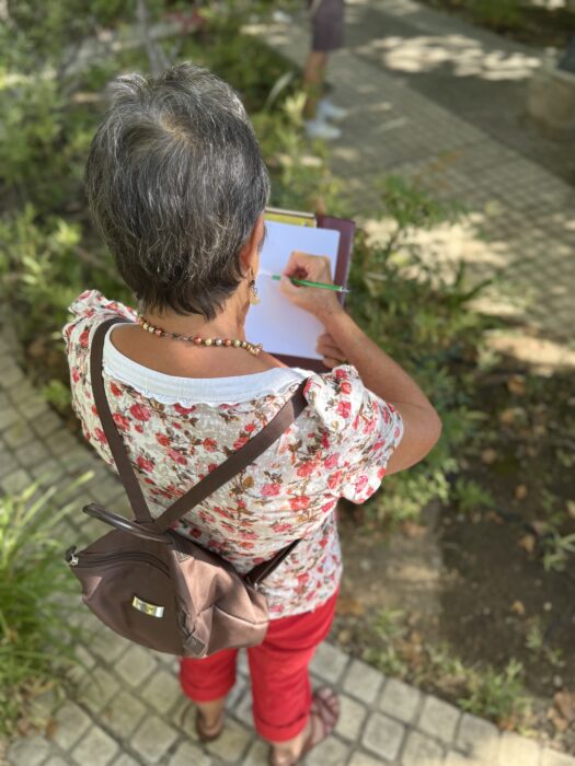 Une participante à la balade dessinée des Journées du patrimoine dessine en plein air, sur un chemin végétalisé à La Farlède.
